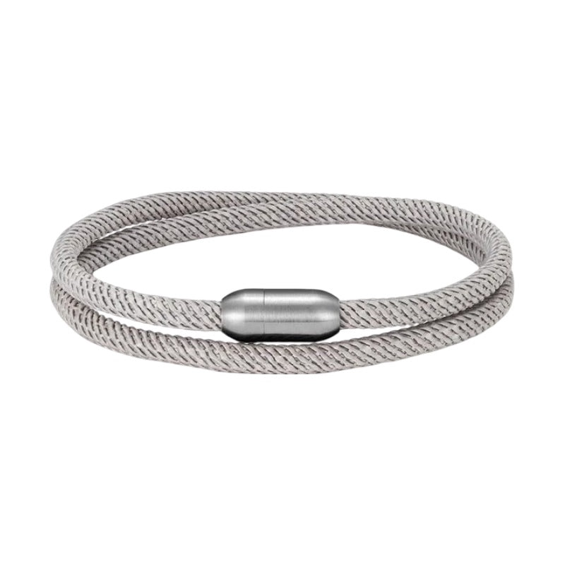 Bracelet double cordon en nylon gris clair avec fermoir magnétique argenté, style minimaliste et unisexe.