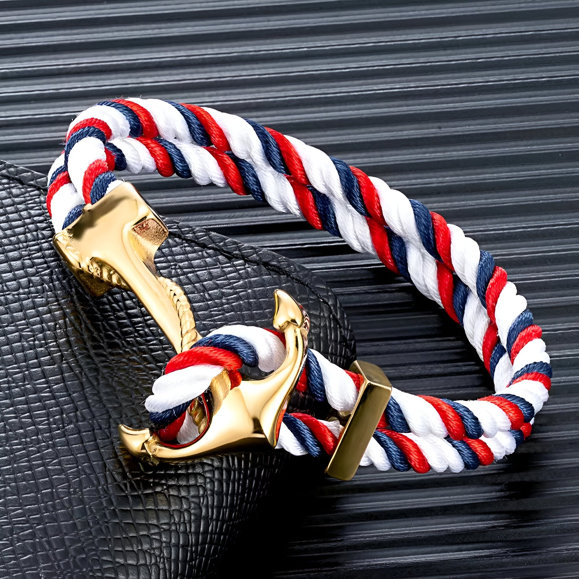 Bracelet double cordon bleu, blanc et rouge avec motif ancre dorée brillant et fermoir doré.
