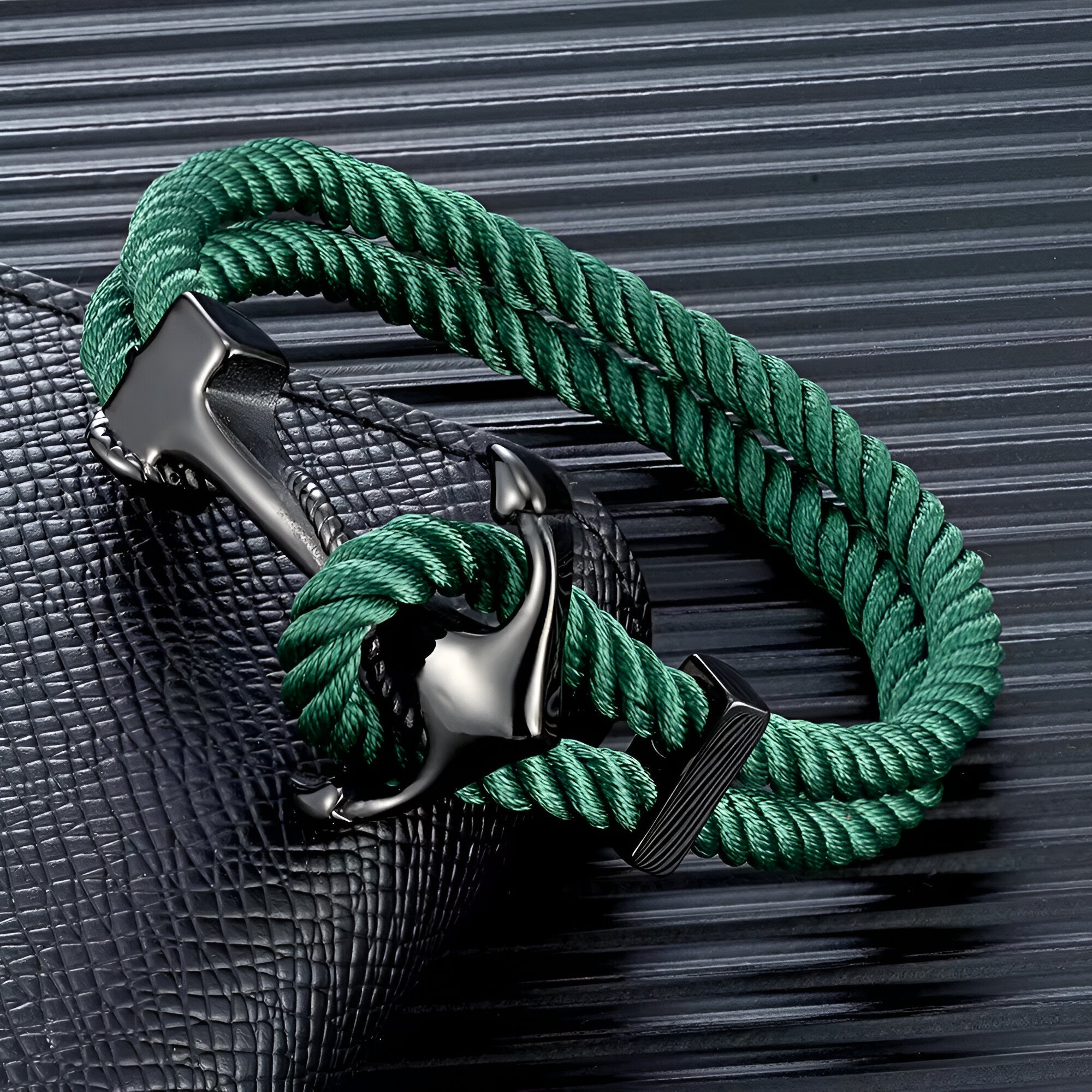 Bracelet double cordon vert menthe avec motif ancre noire en métal brillant.