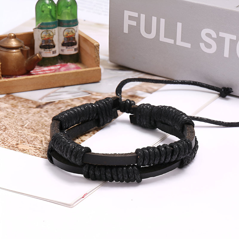 Bracelet double en cuir noir tressé avec finition cirée et fermeture ajustable par cordon.