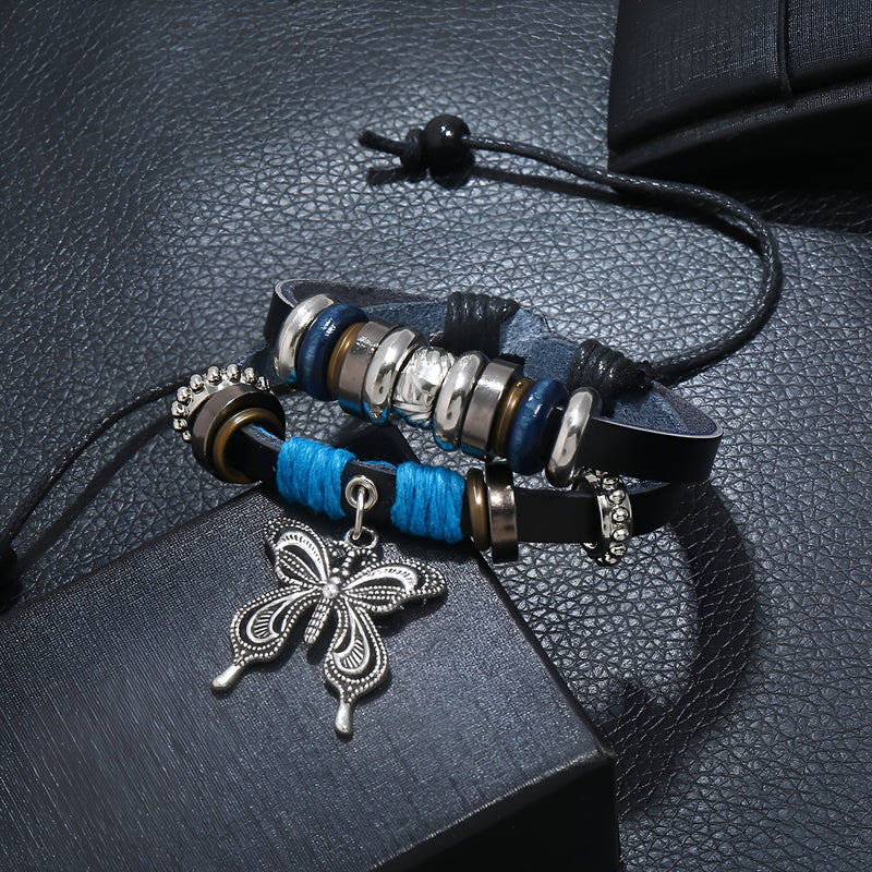 Bracelet double en cuir bleu avec charms papillon argenté et perles décoratives noires et argentées.