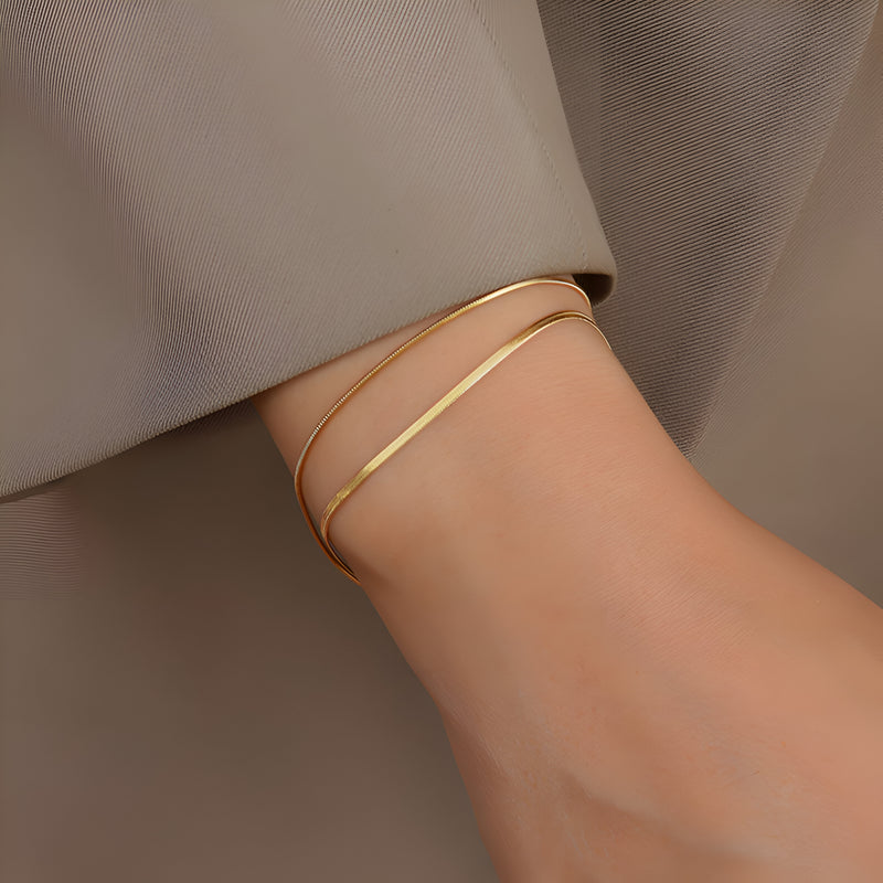 Bracelet double rang en titane plaqué or, design fin et épuré, style élégant pour femme.