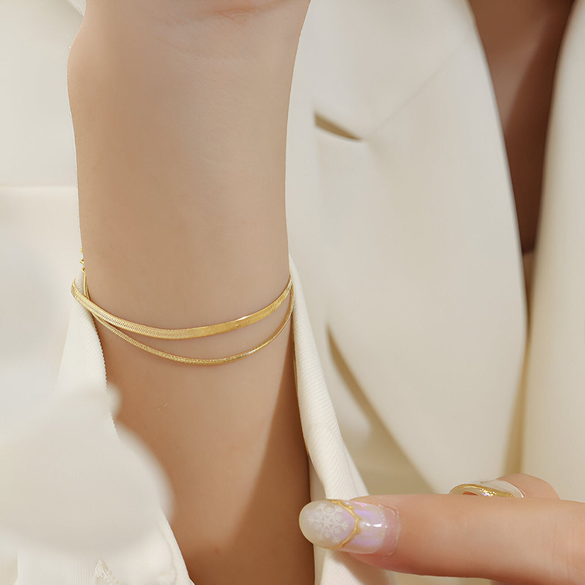 Bracelet double rang en titane plaqué or, lignes fines et élégantes sur poignet féminin.