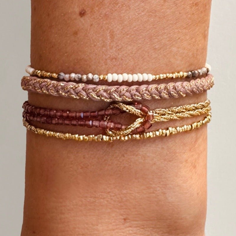 Bracelet double rang en perles du Japon roses et dorées, corde dorée torsadée, fermoir mousqueton, nœud décoratif lumineux.