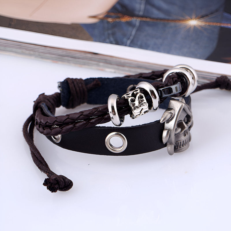 Bracelet double-rangs en cuir noir avec tête de mort argentée et détails nattés.