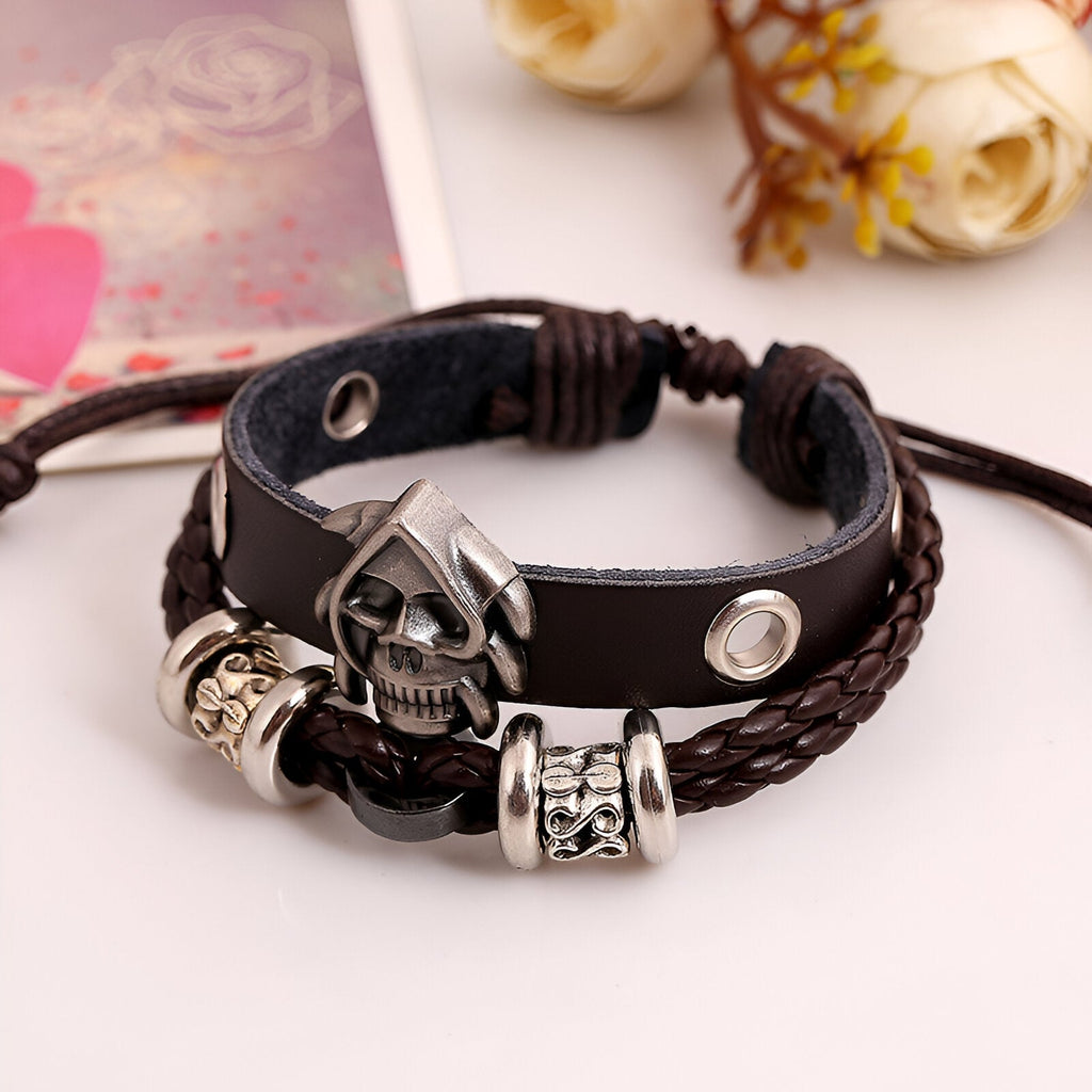 Bracelet double rangs en cuir marron, tête de mort argentée et perles décoratives en métal.