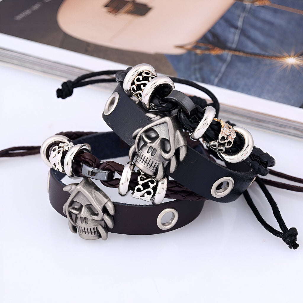 Bracelet double-rangs en cuir noir et marron avec tête de mort en métal argenté et détails gravés.