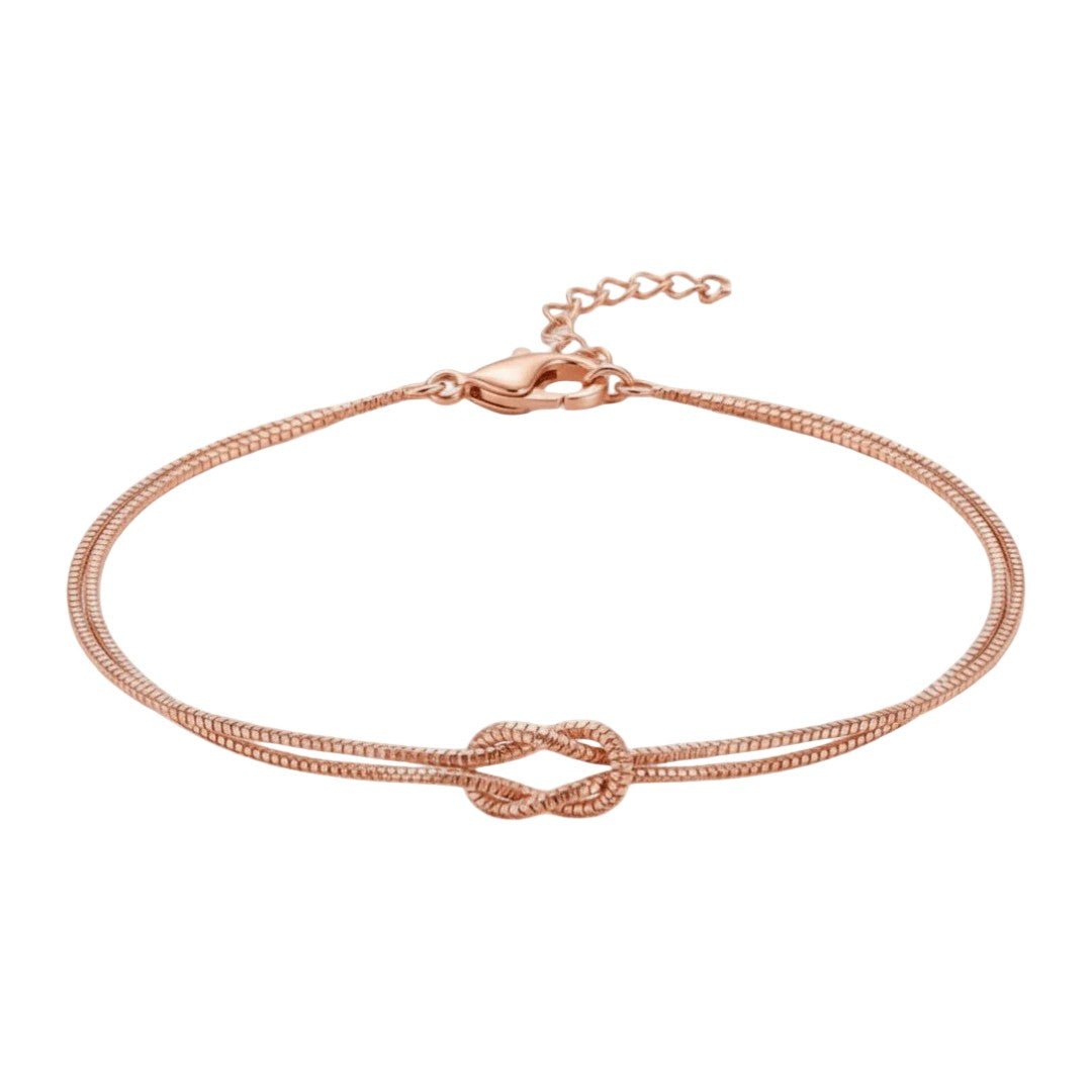 Bracelet en acier inoxydable rose avec nœud central et chaîne fine réglable.