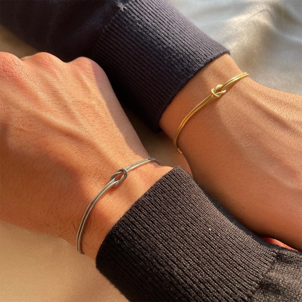 Bracelet fin en acier inoxydable argenté à nœud central minimaliste sur poignet masculin Bracelet fin en acier inoxydable.
