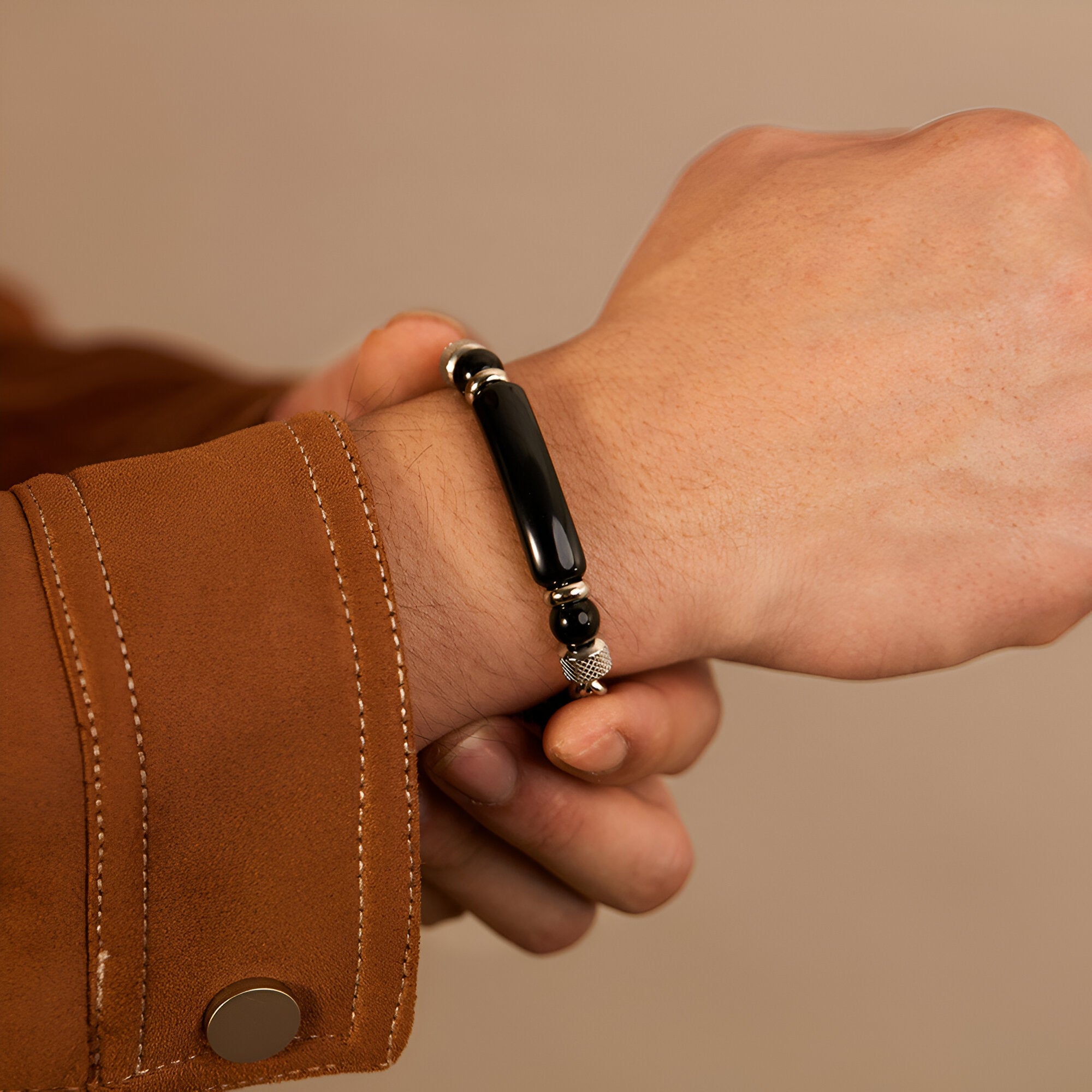 Bracelet homme acier inoxydable avec perle œil de tigre noir et détails argentés.