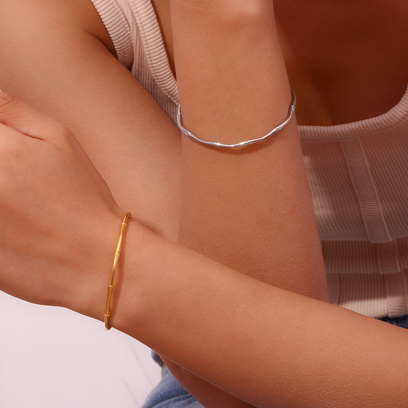 Bracelet fin en acier inoxydable plaqué or 18 carats avec motif bambou, style minimaliste.