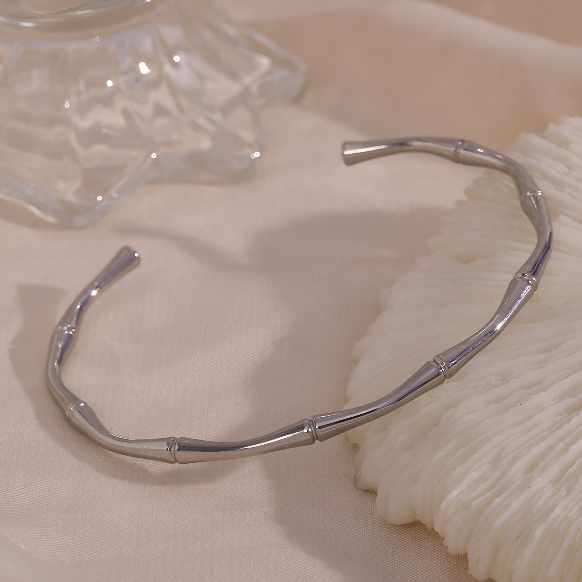 Bracelet rigide en acier inoxydable argenté avec design bambou sculpté, style minimaliste.