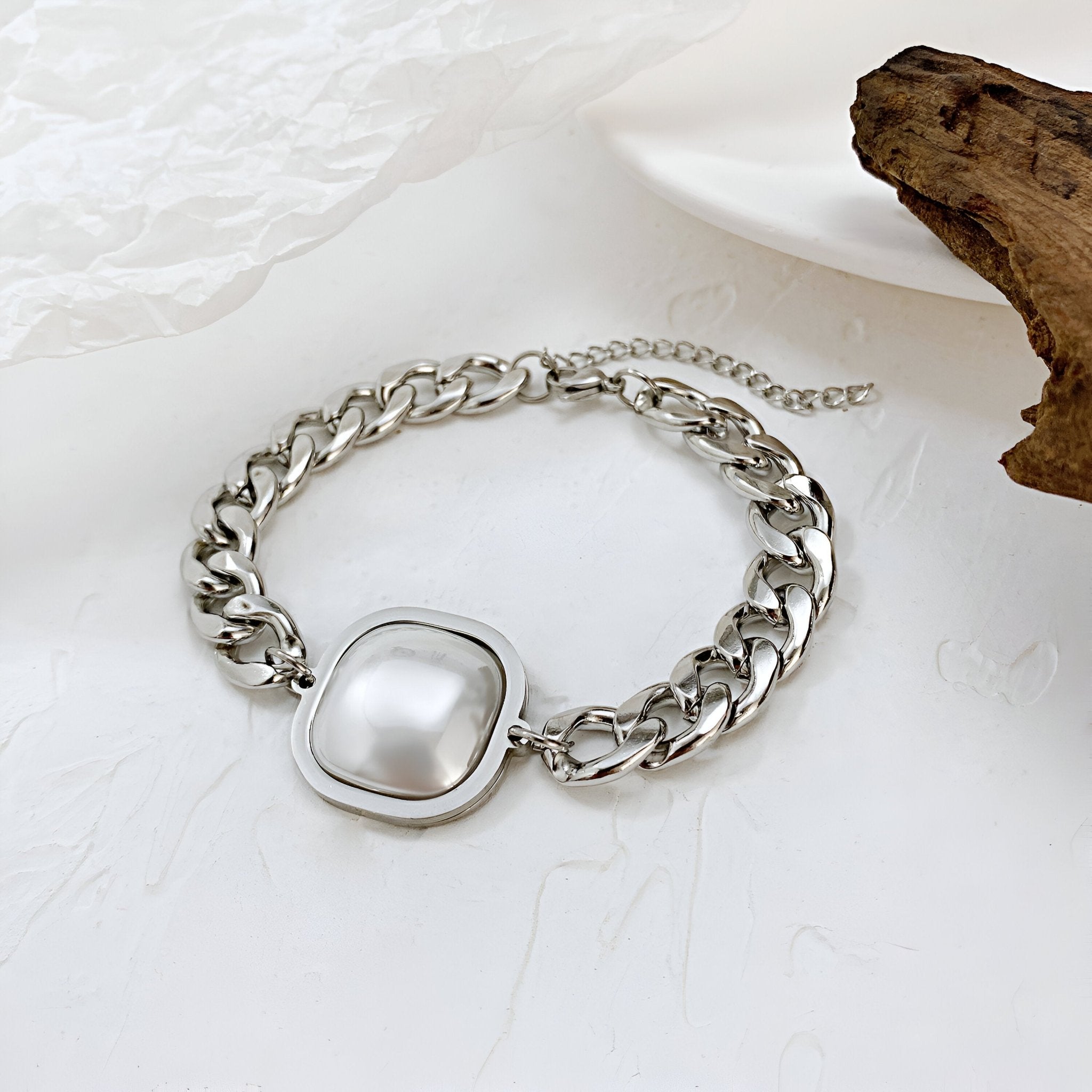 Bracelet homme en acier inoxydable argenté avec maillons larges et détail central blanc nacré carré.