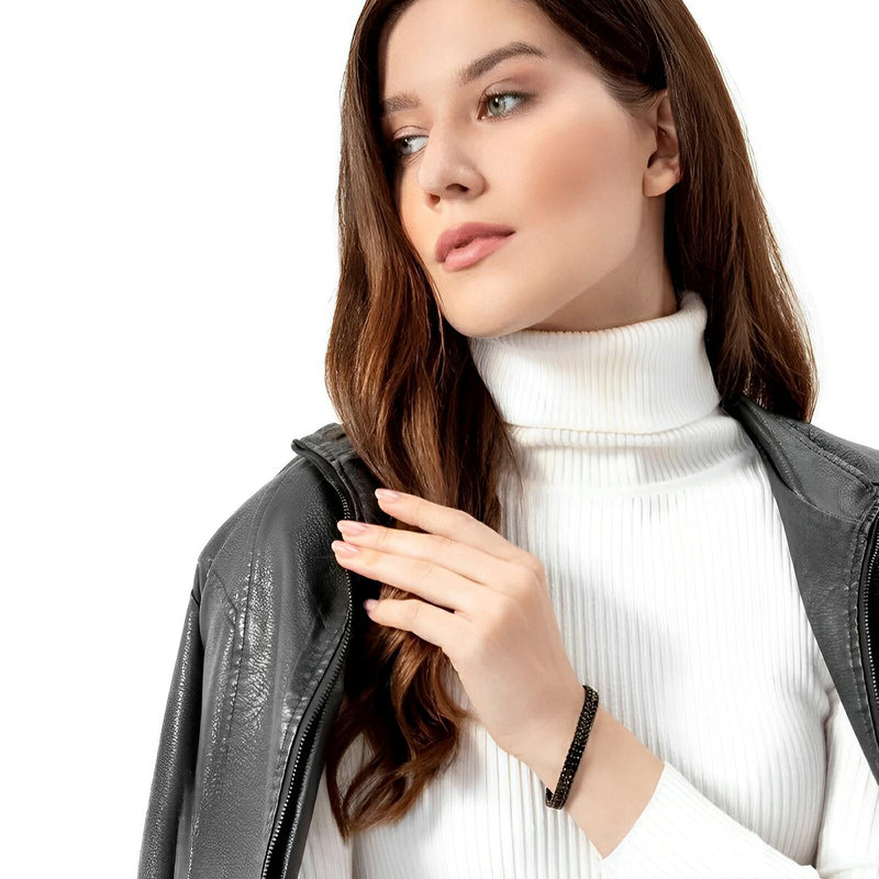 Bracelet en maille spiga noire en acier inoxydable porté sur poignet féminin, style moderne et épuré.