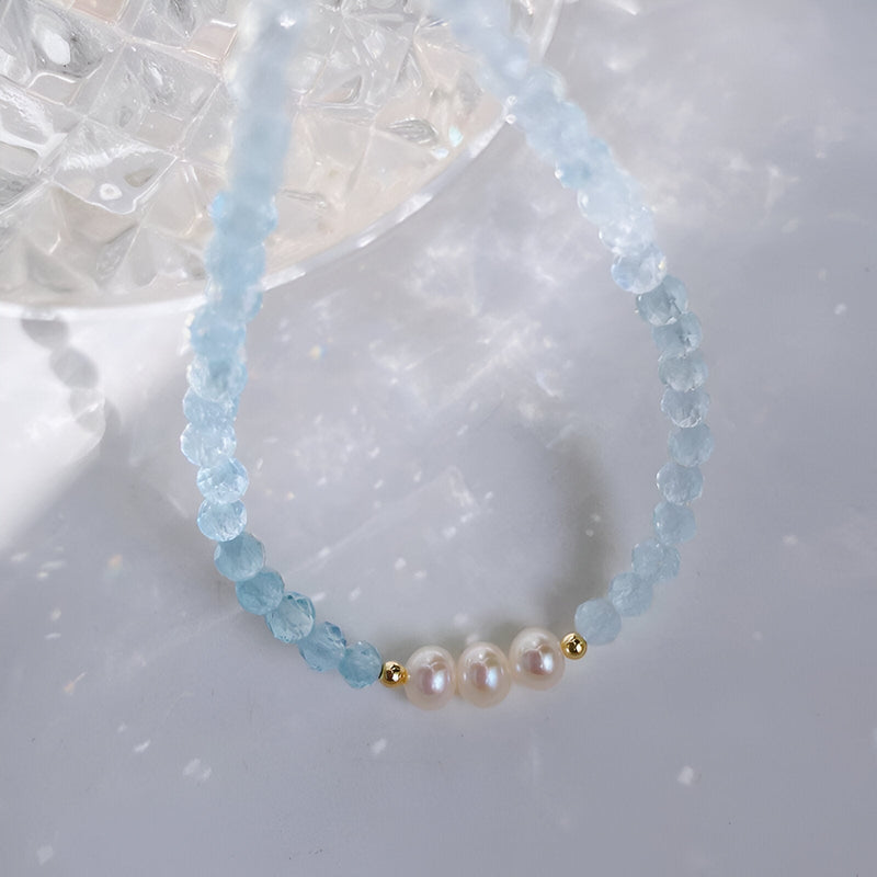 Bracelet en argent sterling avec perles d'aigue-marine bleues et trois perles blanches au centre.