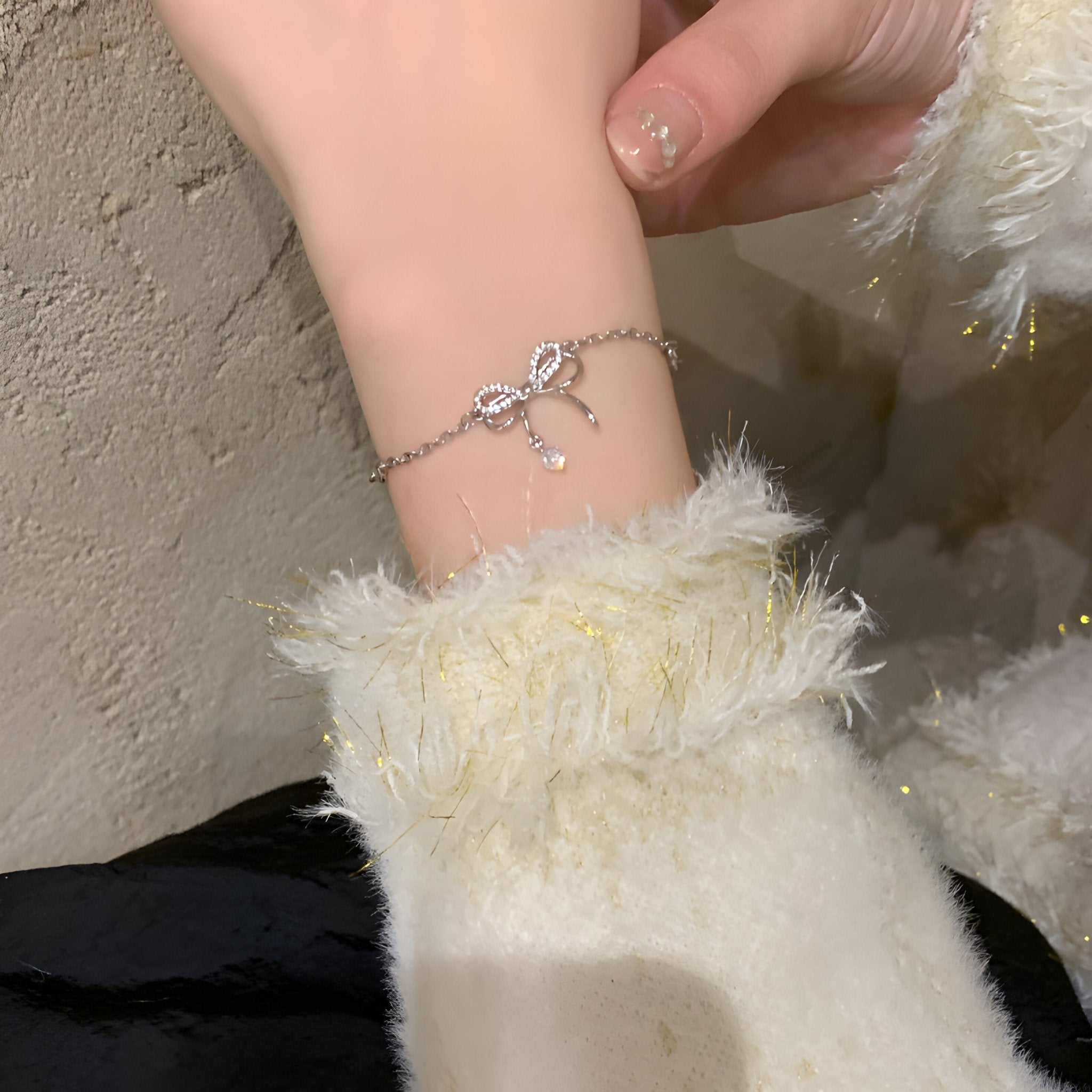 Bracelet en argent sterling avec ornement noeud délicat sur poignet féminin, chaîne fine.