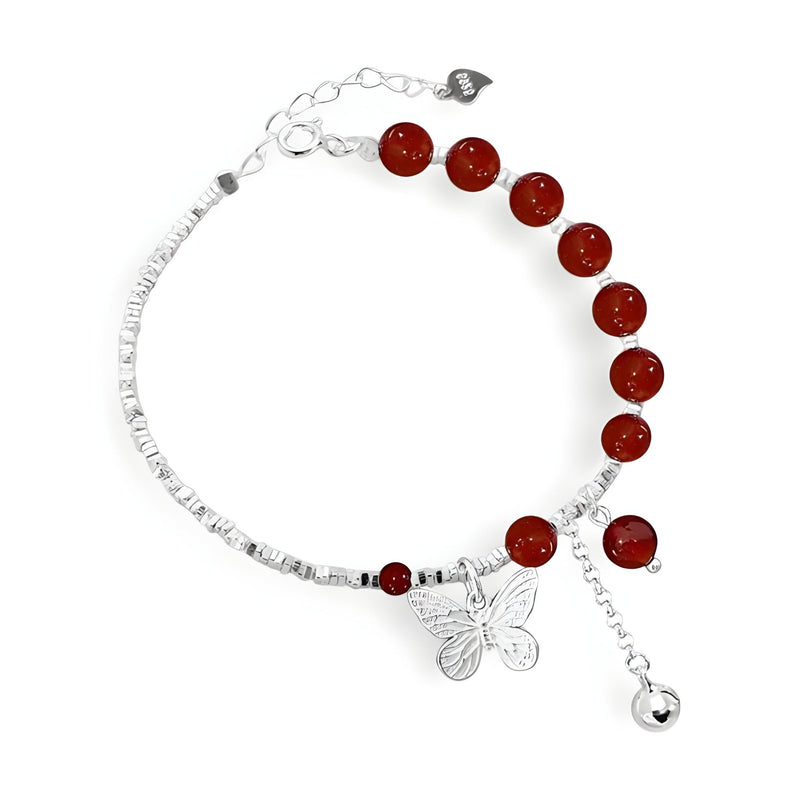 Bracelet en argent sterling avec perles d'agate rouge et pendentif papillon détaillé.
