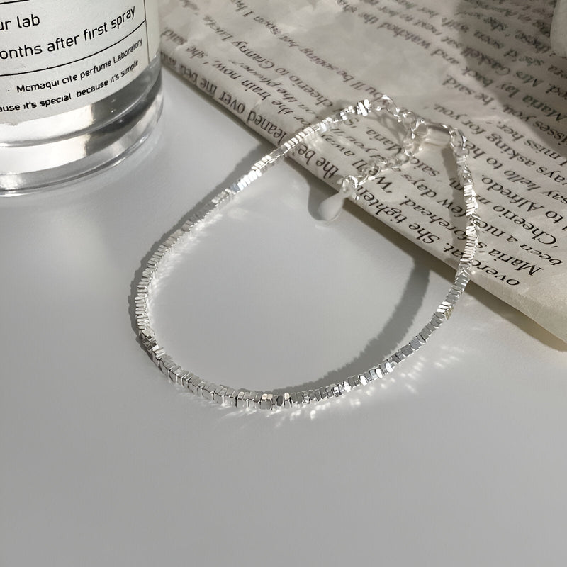 Bracelet fin en argent sterling avec maillons brillants, style élégant et épuré.