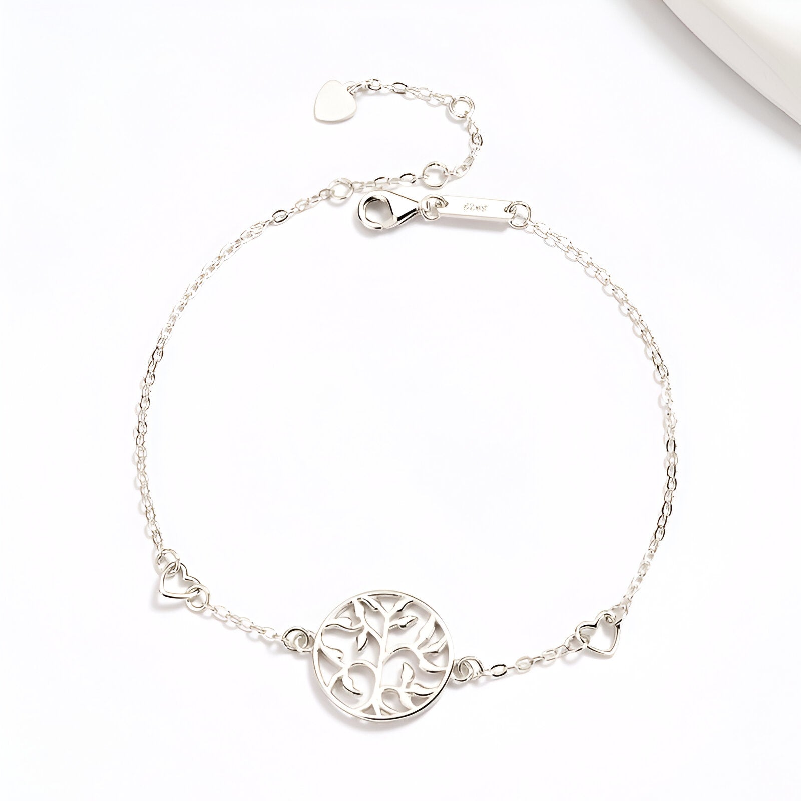Bracelet argent sterling fin avec pendentif arbre de vie en cercle ajouré et petits cœurs aux extrémités.