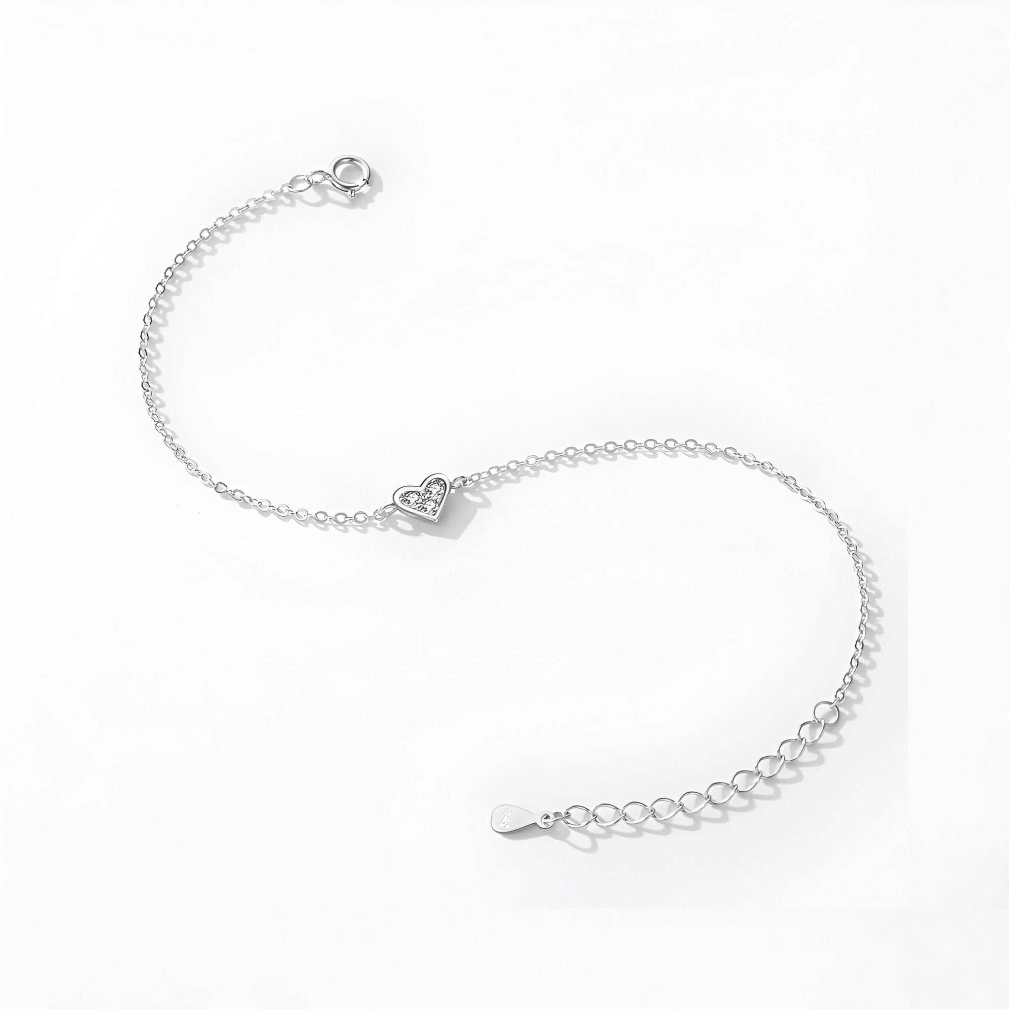 Bracelet fin en argent sterling avec pendentif cœur détaillé et chaîne ajustable.