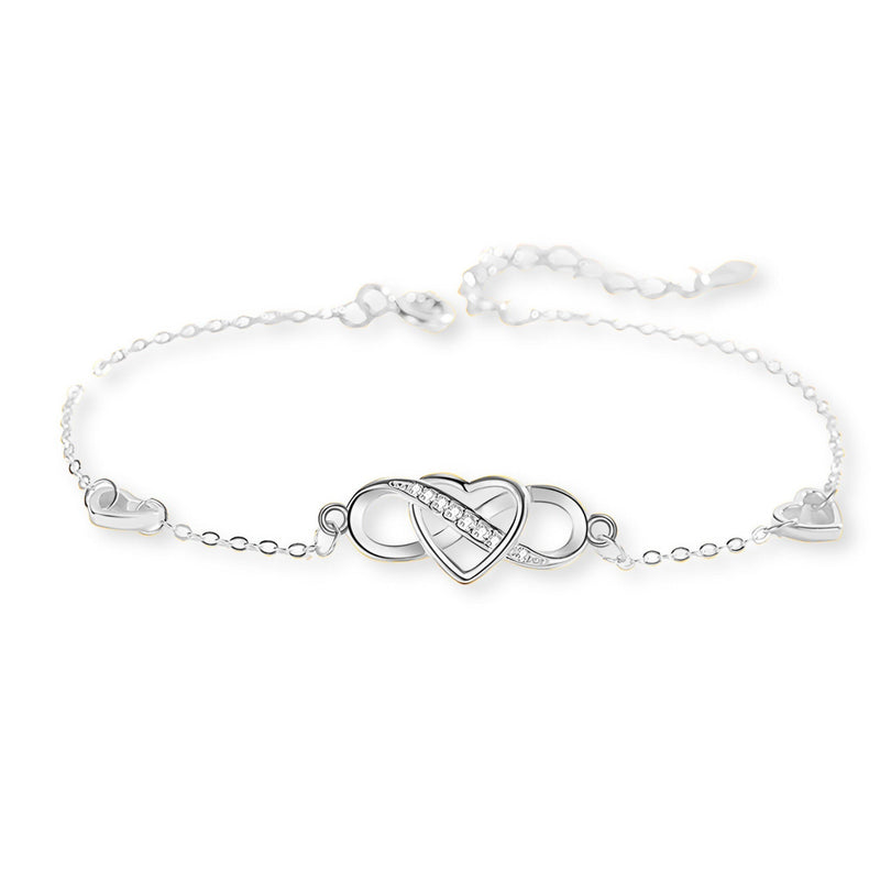 Bracelet en argent sterling fin avec charm infini et cœur entrelacé au centre.