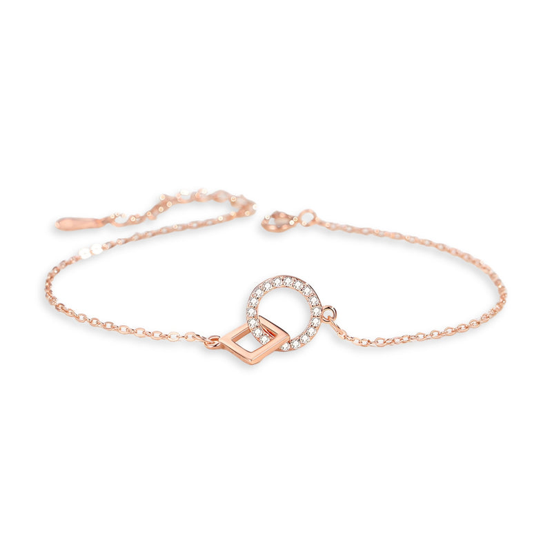 Bracelet en or rosé avec charms géométriques entrelacés et détail de petits cristaux blancs.