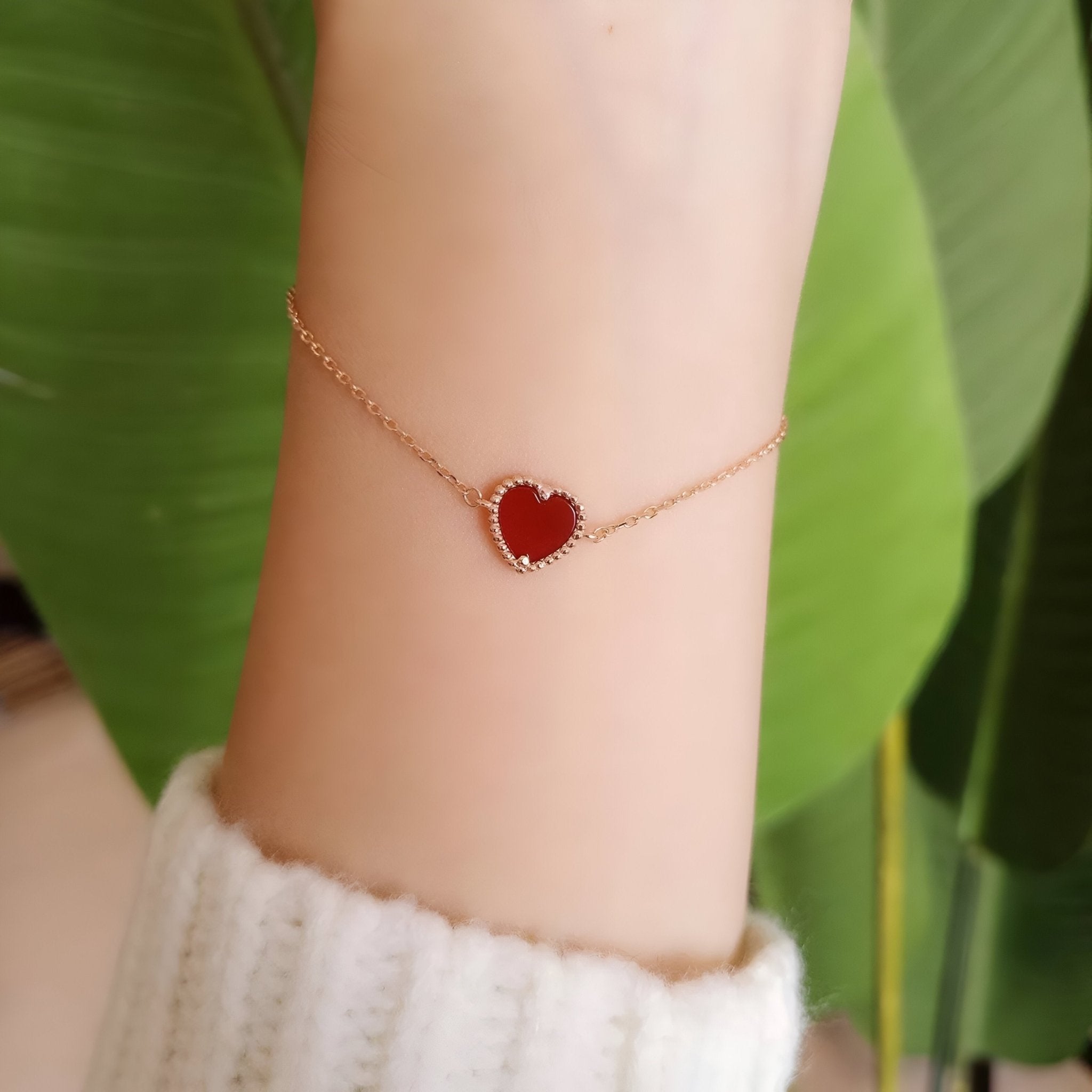 Bracelet fin en argent or rosé avec un pendentif cœur rouge, style délicat pour femme.