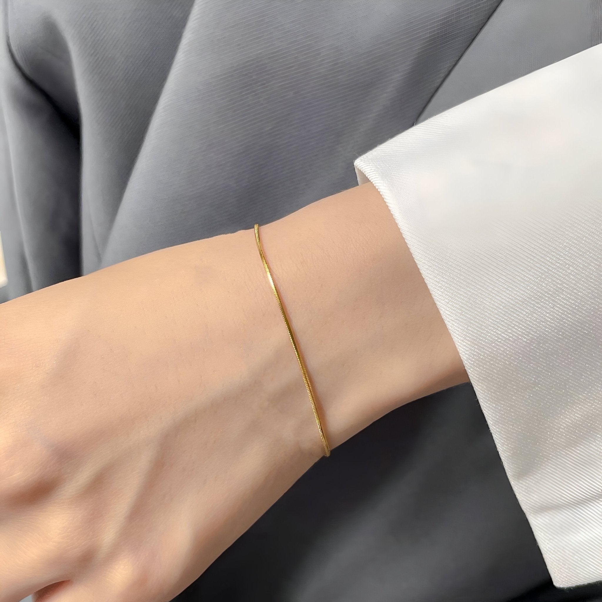Bracelet fin en argent sterling brillant porté autour du poignet féminin, style minimaliste élégant.