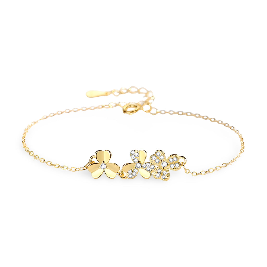 Bracelet en or avec pendentifs trèfle à trois feuilles, chaîne fine et fermoir ajustable.