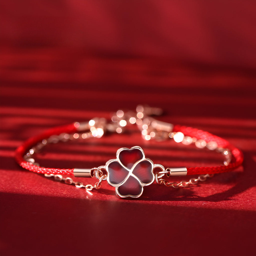 Bracelet en argent sterling avec trèfle à 4 feuilles changeant de couleur sur cordon rouge fin.
