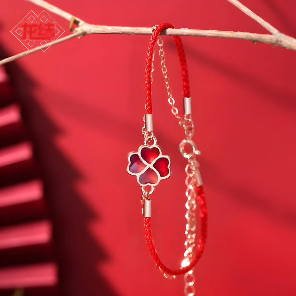 Bracelet en argent sterling avec trèfle à 4 feuilles rouge au centre, cordon rouge ajustable.