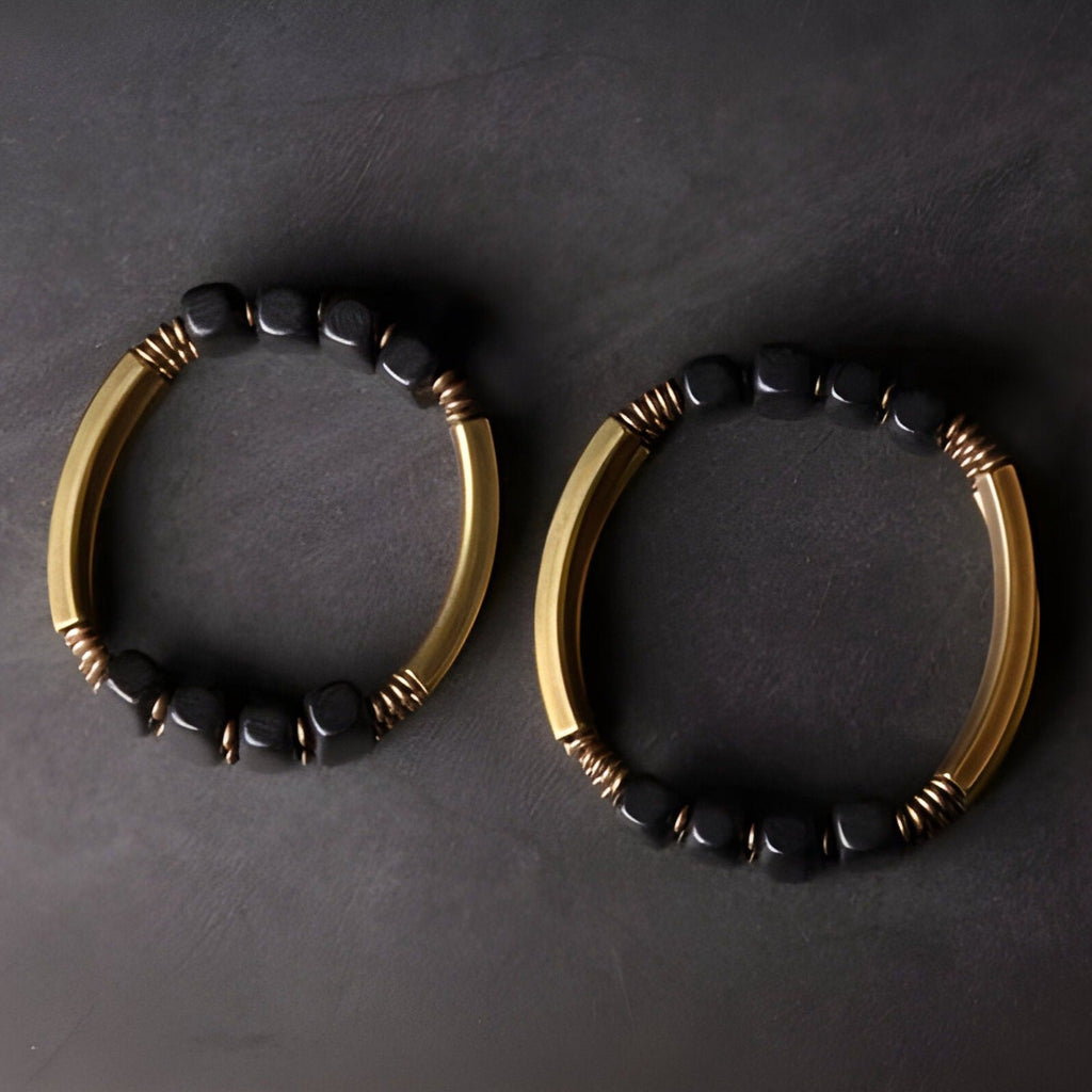 Bracelet flexible pour femme en bois d’ébène noir avec tubes en cuivre doré.