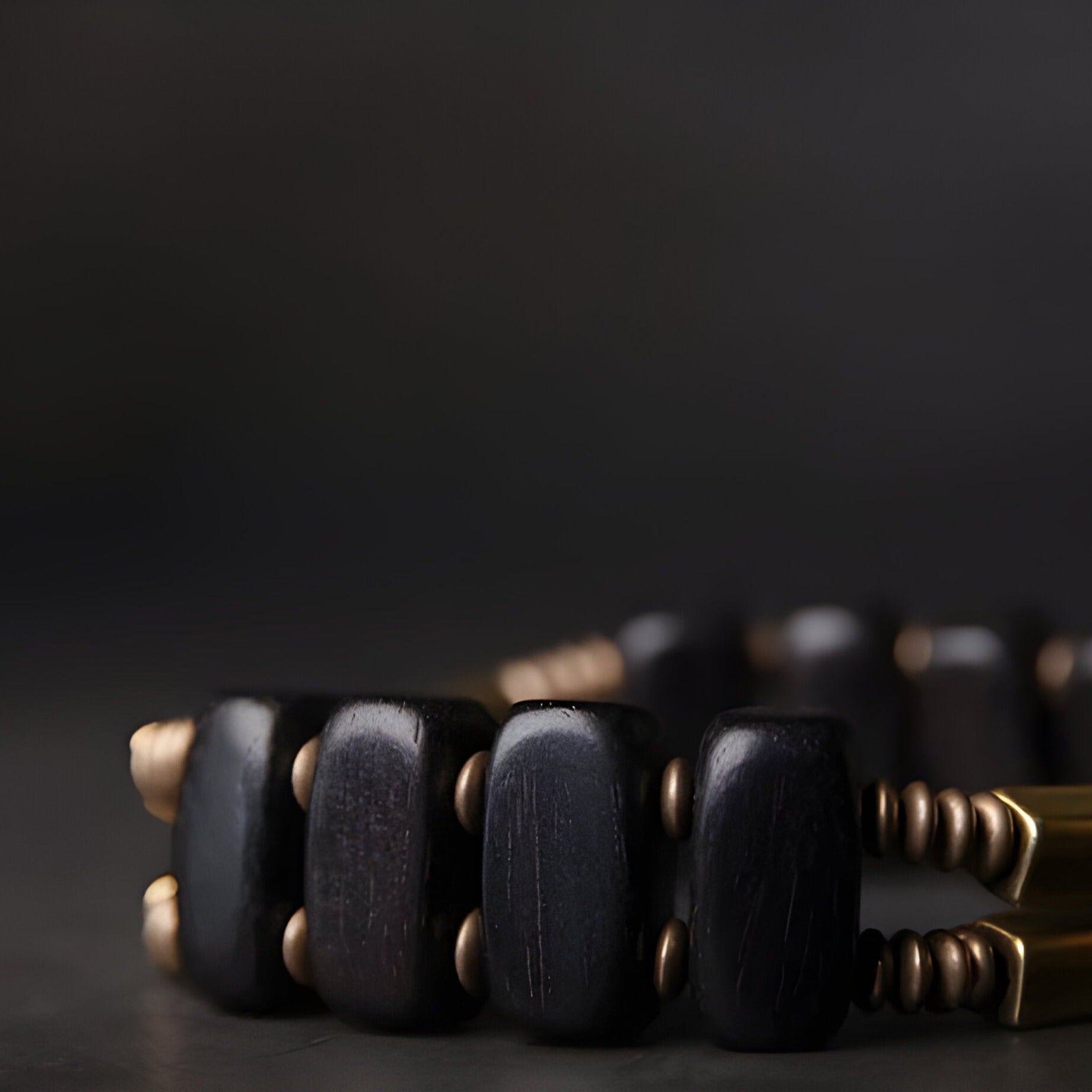 Bracelet flexible femme en bois d'ébène noir mat et perles cuivre brillante, design moderne.