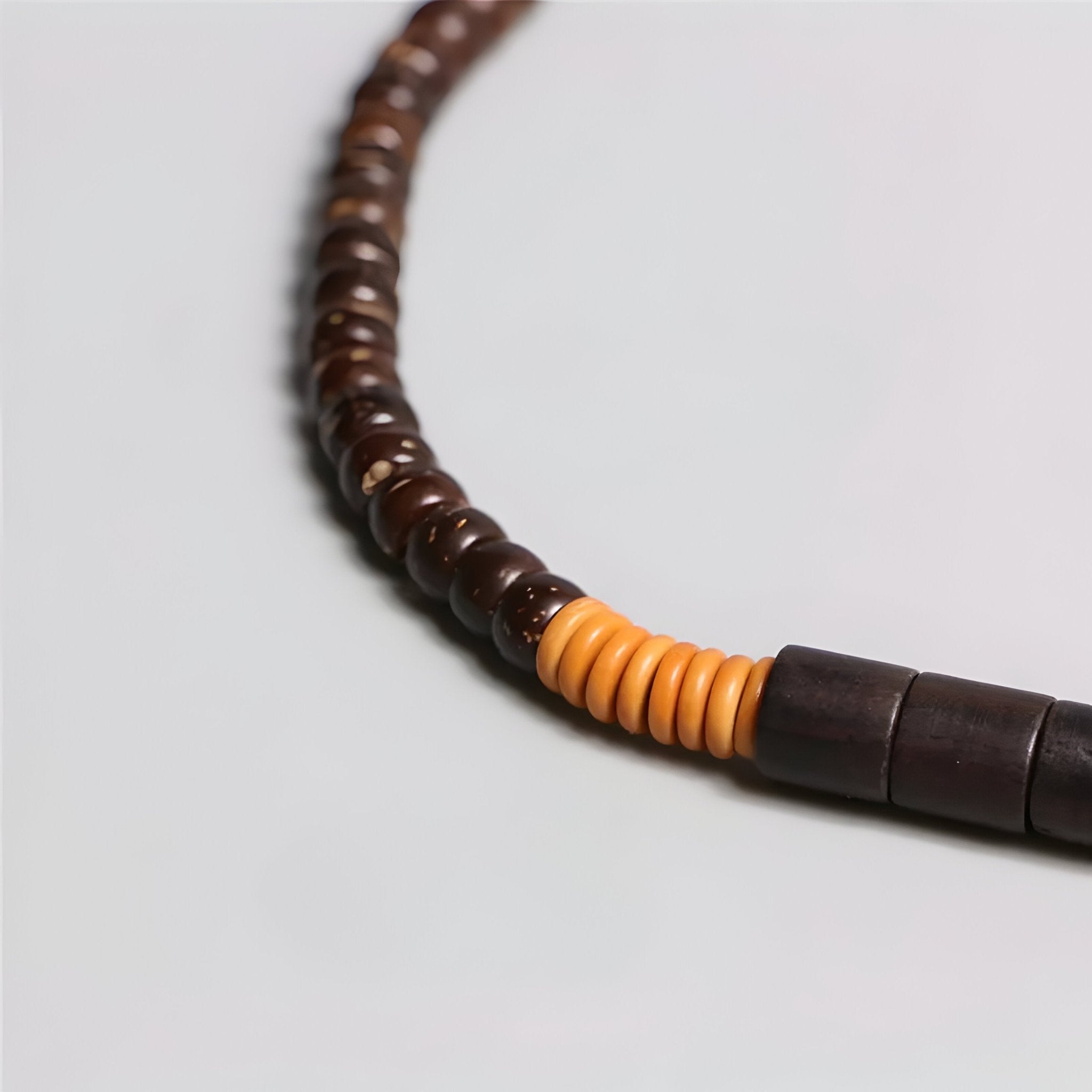 Bracelet mixte en bois d’ébène noir et perles d’obsidienne avec section en perles rondes orange naturel.