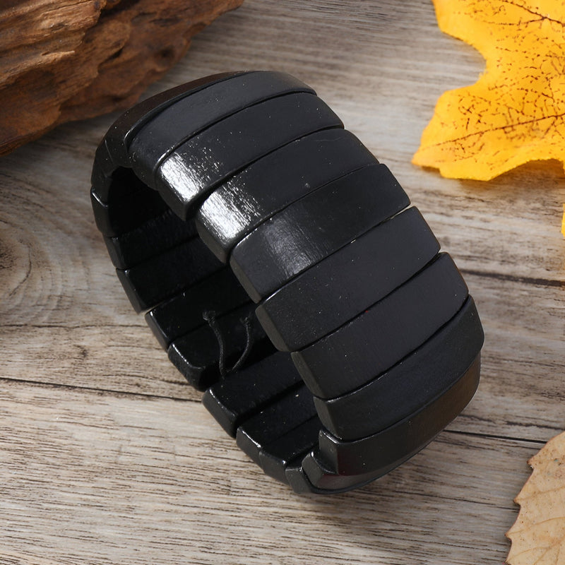 Bracelet large en bois naturel laqué noir, design segmenté et moderne pour femme.