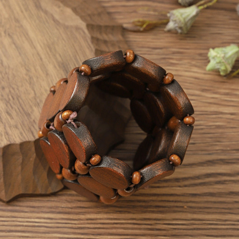Bracelet femme en bois naturel foncé avec perles arrondies, style original et artisanal.