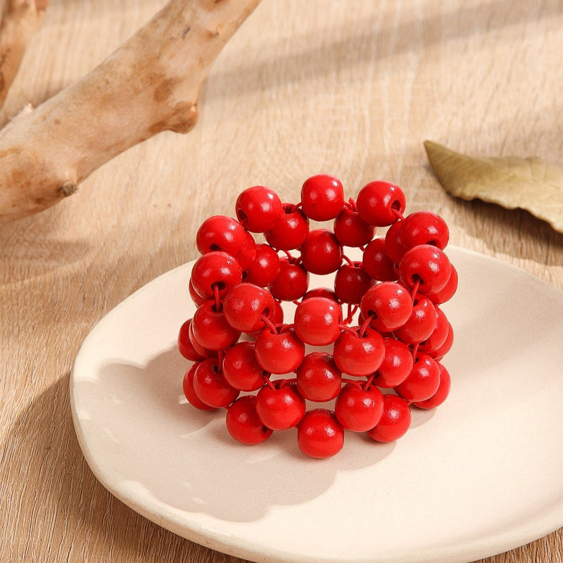 Bracelet femme en bois naturel avec multiples perles rouges rondes, style empilé.
