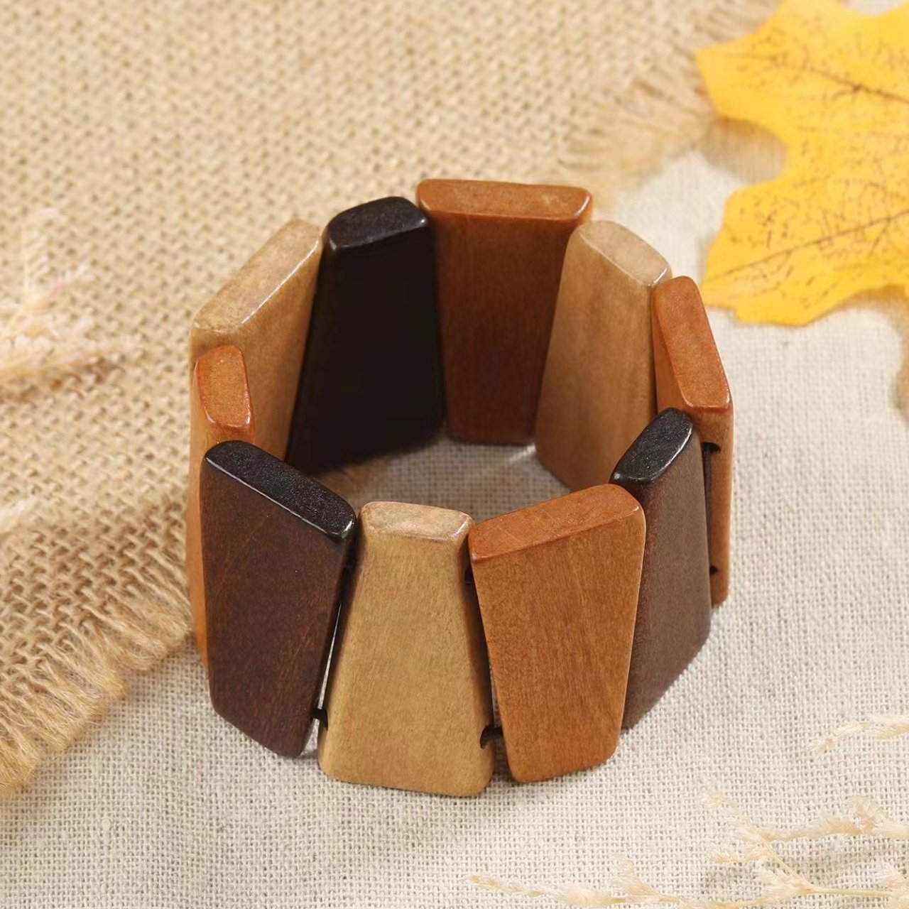 Bracelet manchette femme en bois naturel avec segments triangulaires marron clair, foncé et beige.