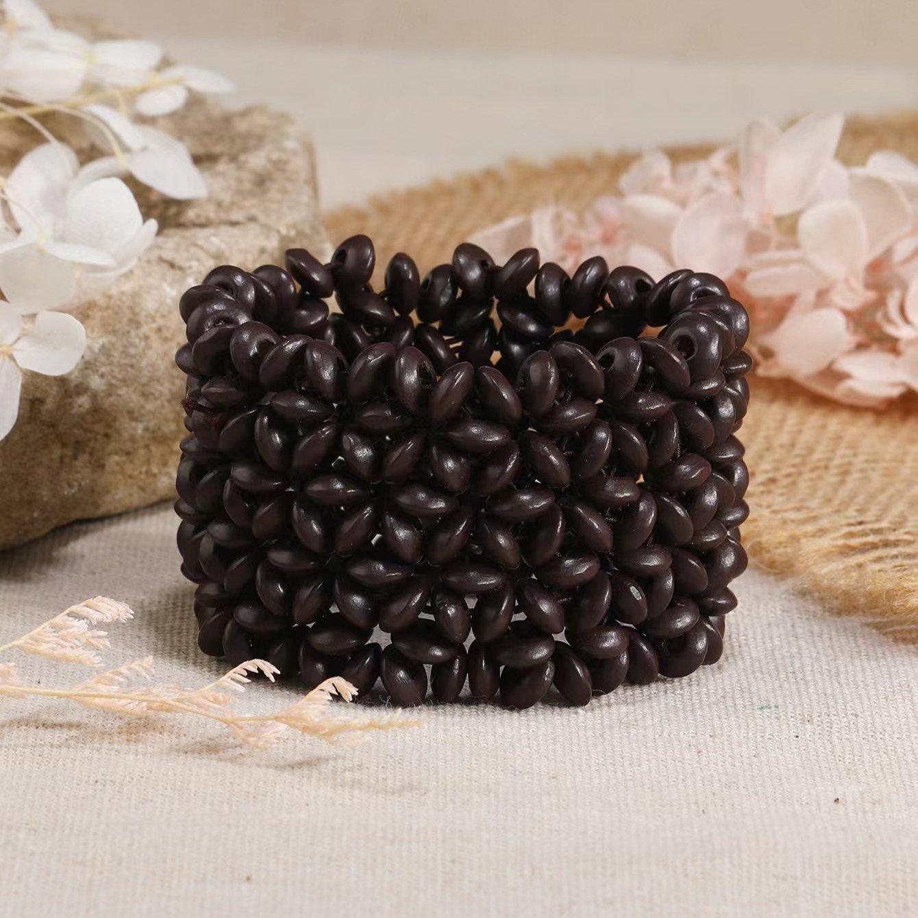 Bracelet large en bois naturel café avec motif floral sculpté, style bohème pour femme.