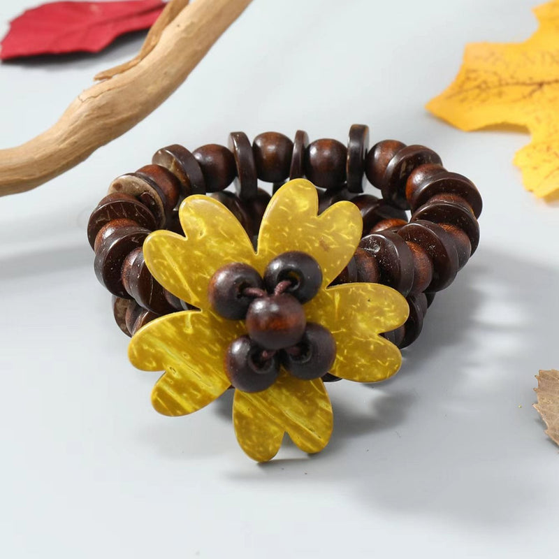 Bracelet café en coquille de noix de coco avec fleur jaune des îles sculptée pour femme.