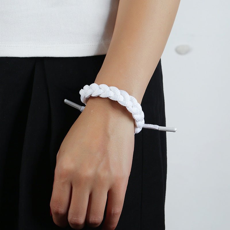 Bracelet en corde tressée blanche, style simple et ajustable, porté au poignet.