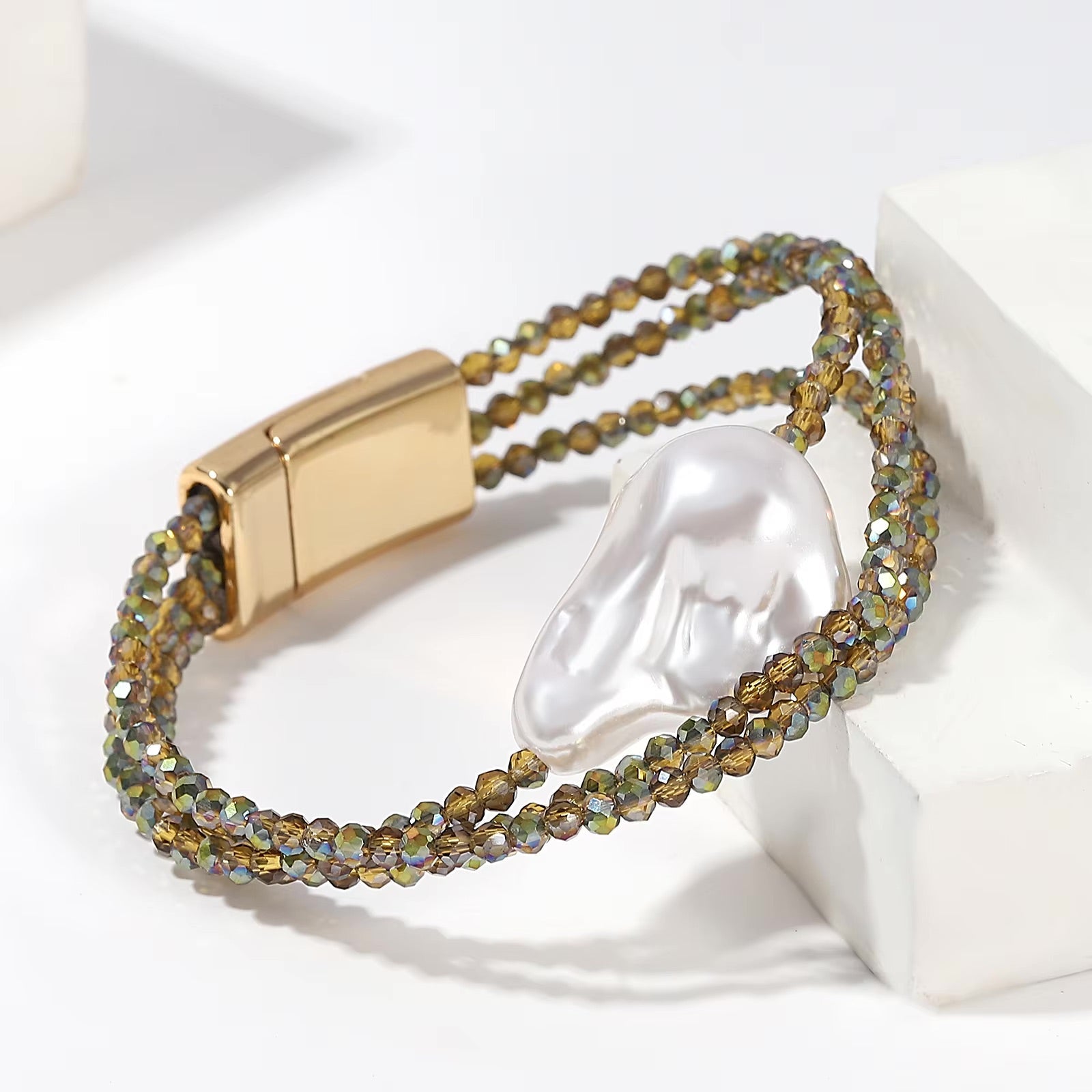 Bracelet femme à double rang de perles kaki brillantes avec grande perle centrale blanche et fermoir doré magnétique.