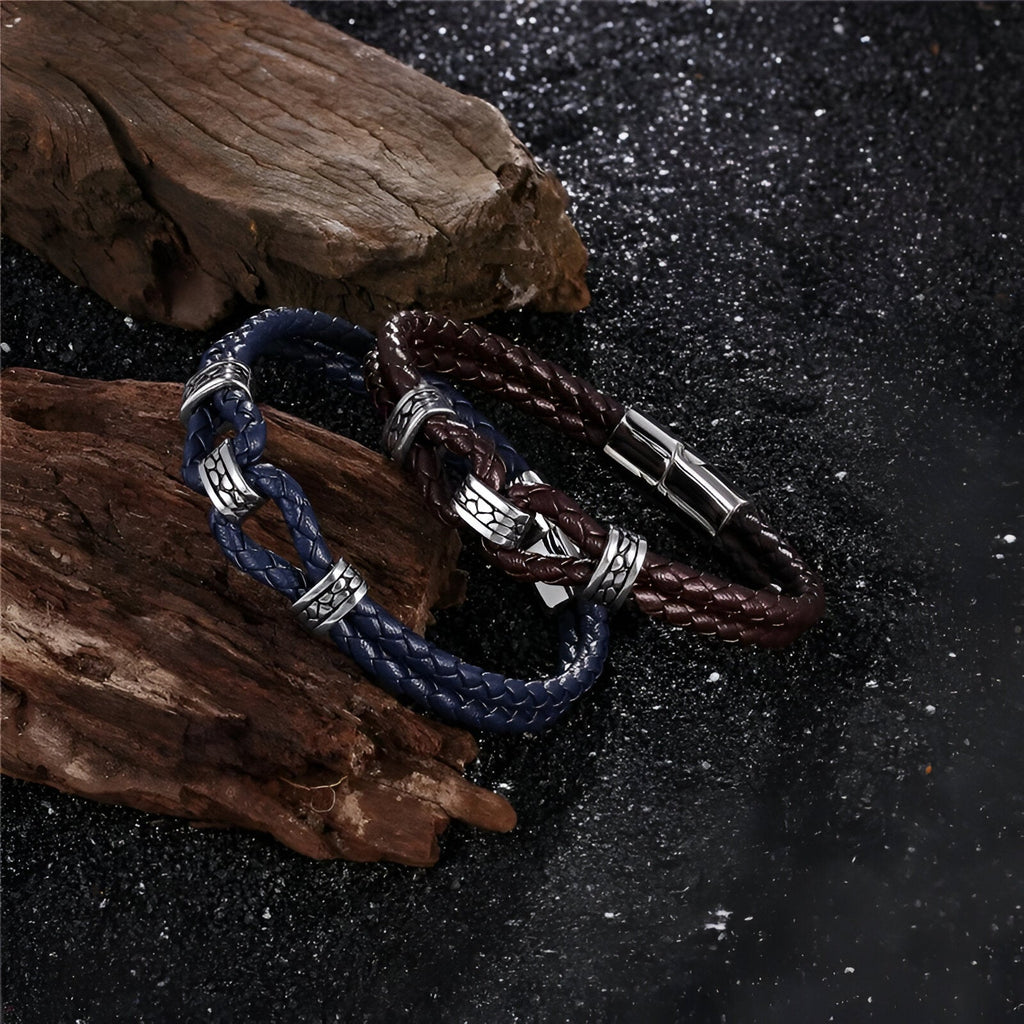 Bracelet en cuir tressé bleu avec nœud coulissant et fermoir métallique argenté sur fond sombre.