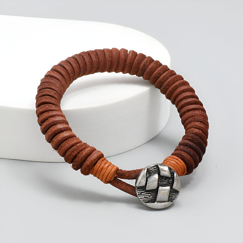 Bracelet en cuir marron tressé pour homme avec fermoir métallique argenté entrelacé.