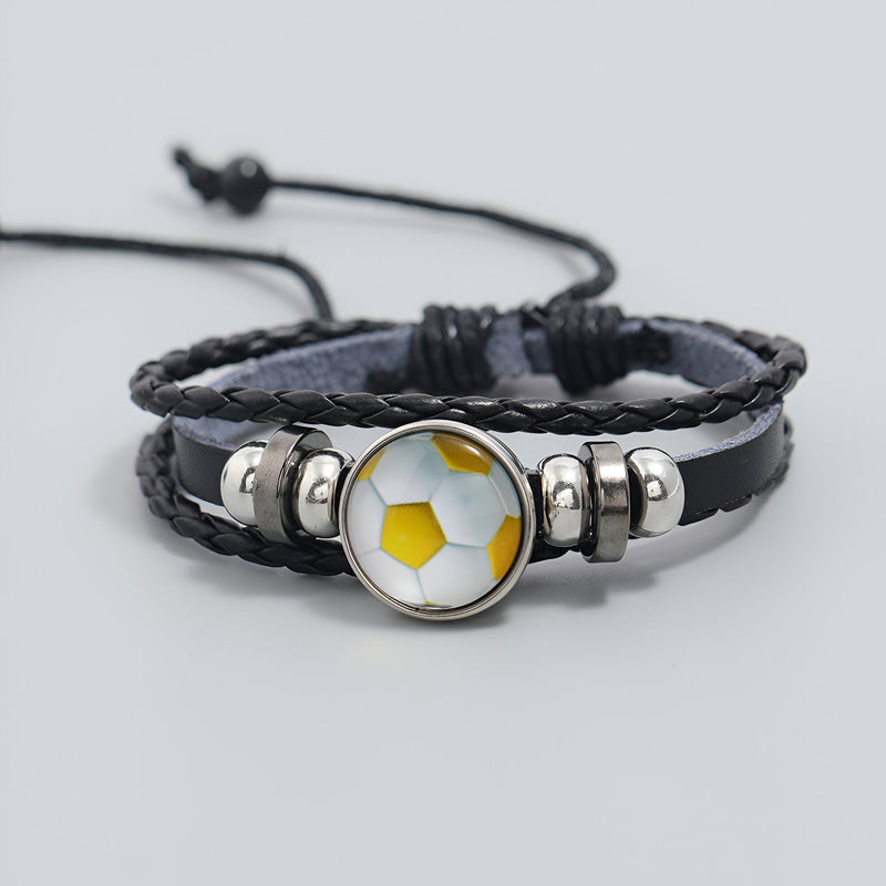 Bracelet en cuir noir tressé avec médaillon football blanc et jaune, fermoir réglable.