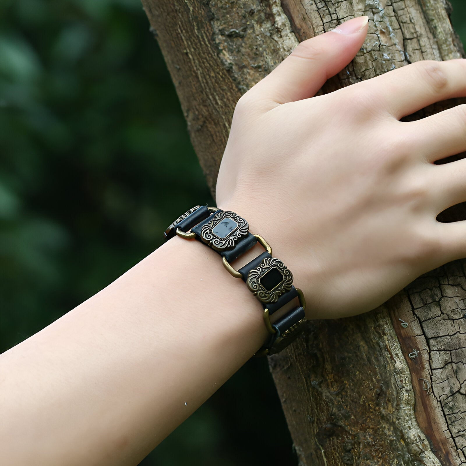 Bracelet en cuir noir avec motifs gravés dorés de style runique, design mixte élégant.