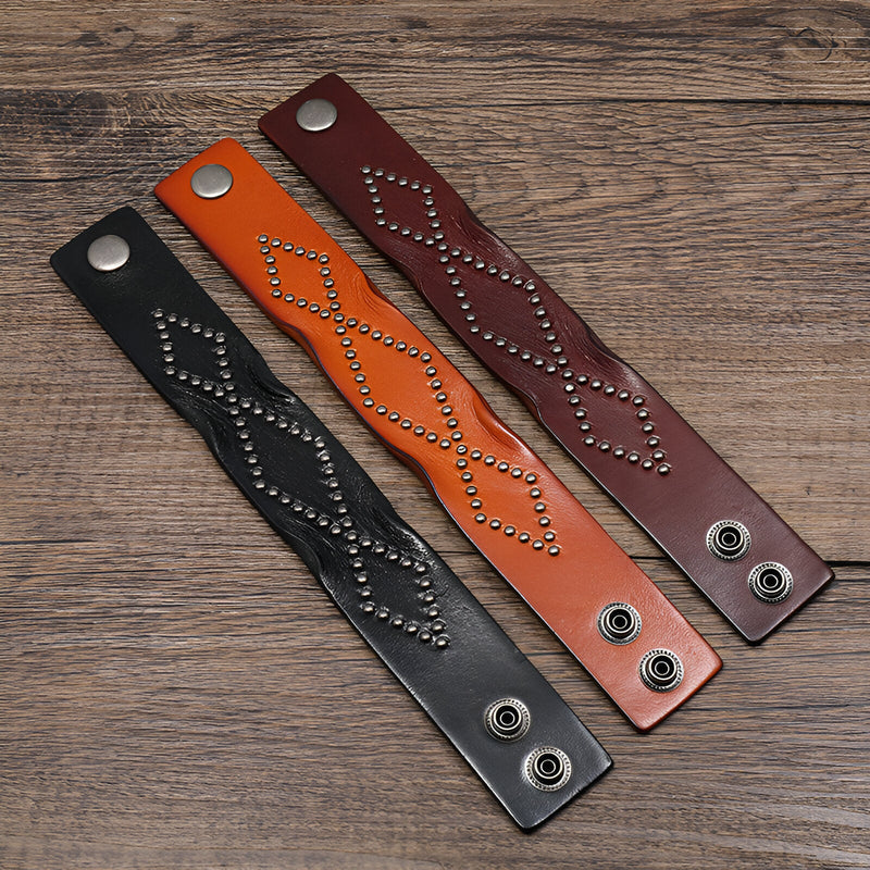 Trois bracelets en cuir clouté style western, couleurs noir, orange et café, fermoirs pression métalliques.