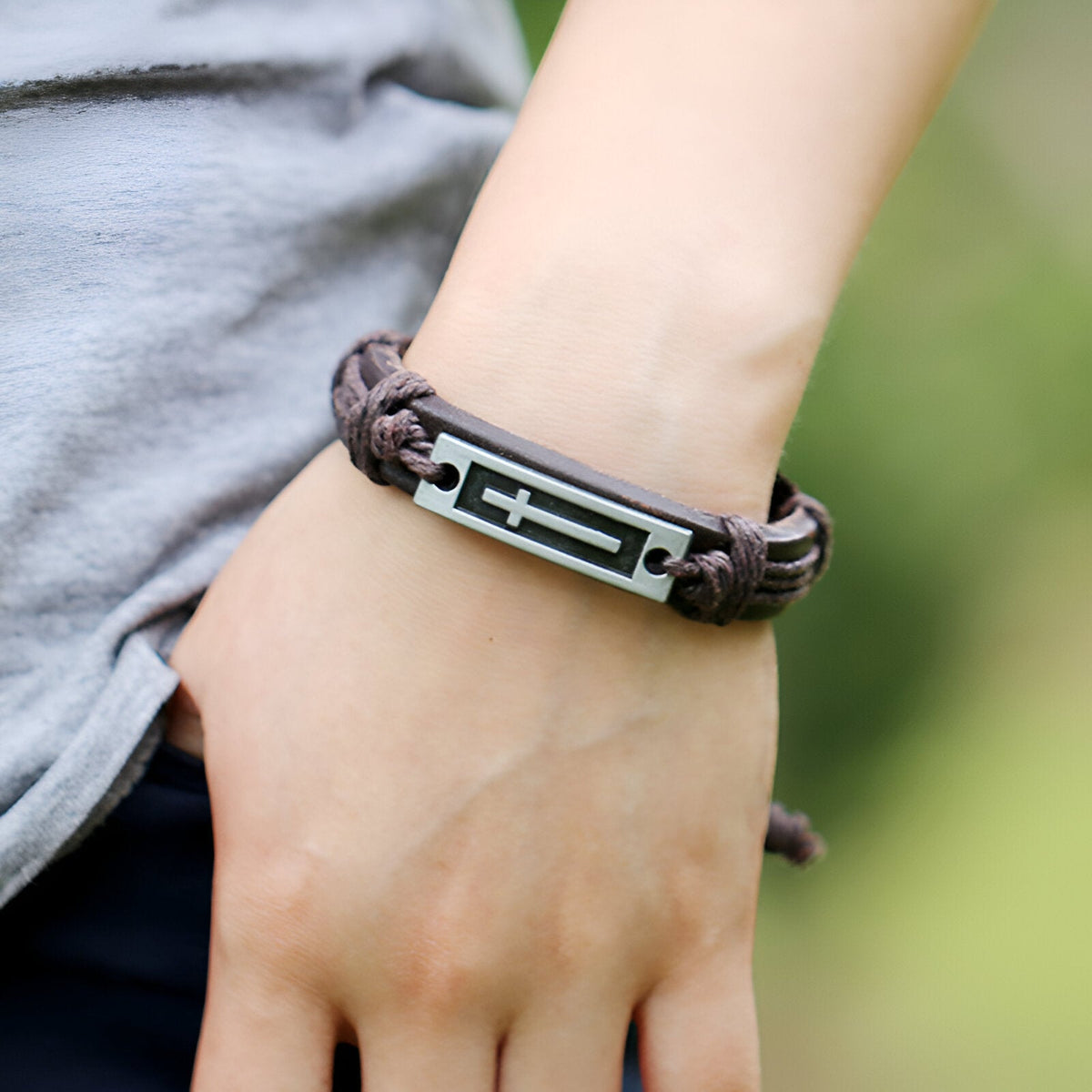 Bracelet cuir marron tressé pour homme avec plaque métal noire et croix chrétienne argentée.
