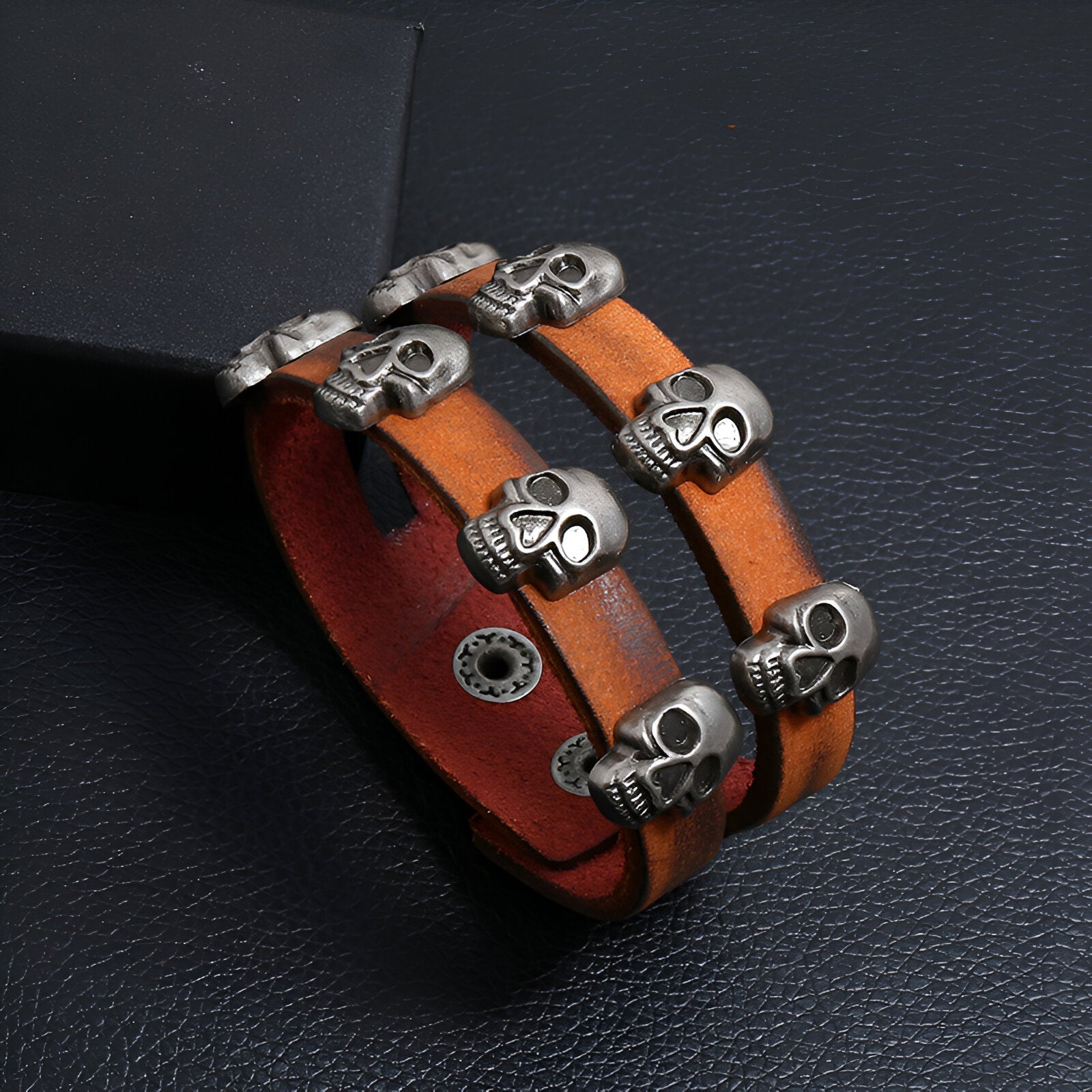 Bracelet en cuir marron double tour avec têtes de mort en métal argenté, style rock pour homme.