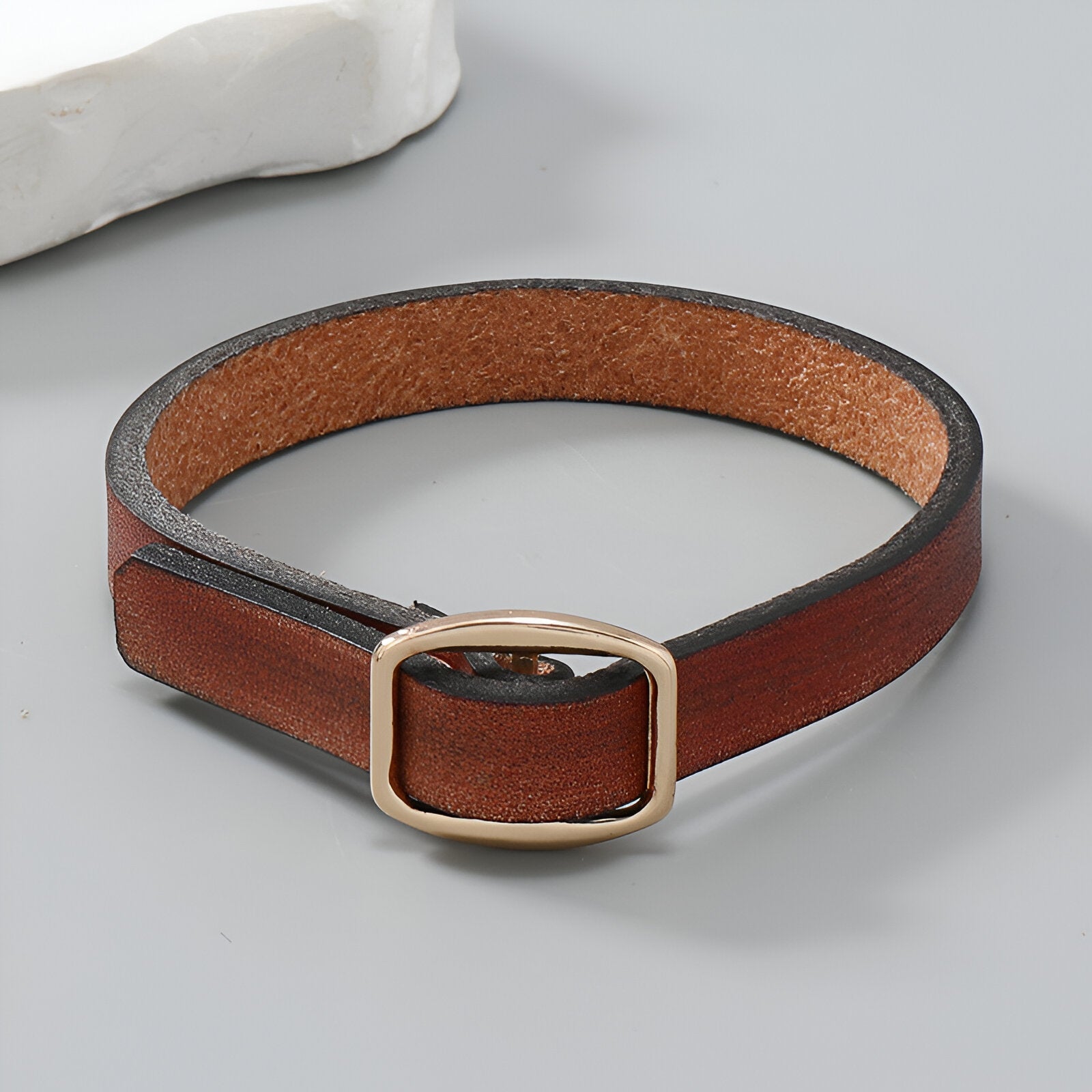 Bracelet en cuir marron avec boucle dorée rectangulaire, style élégant et minimaliste.